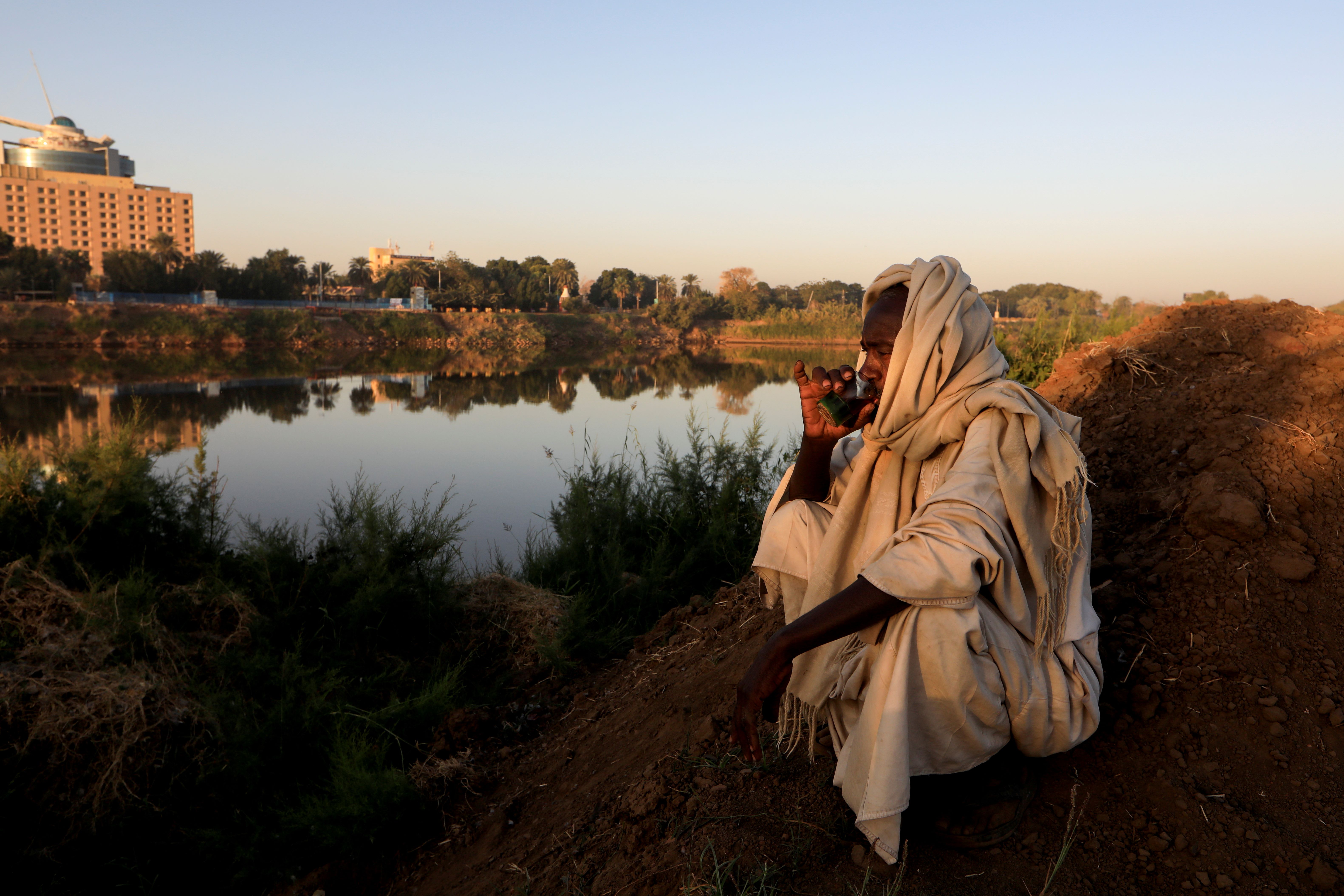 Sudan farmer sipping from a cup 